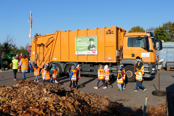 Kinder vor einem Mülltransporter